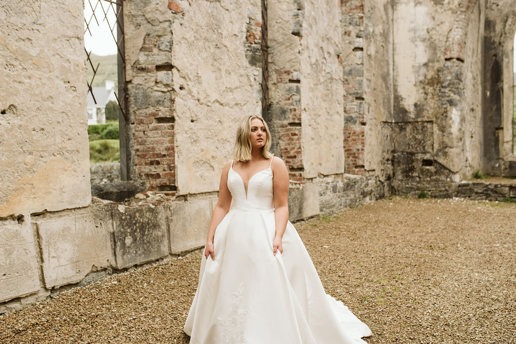 Bride walking through the abandoned Dunlewey Church in Ireland wearing a mikado ballgown wedding dress with straps