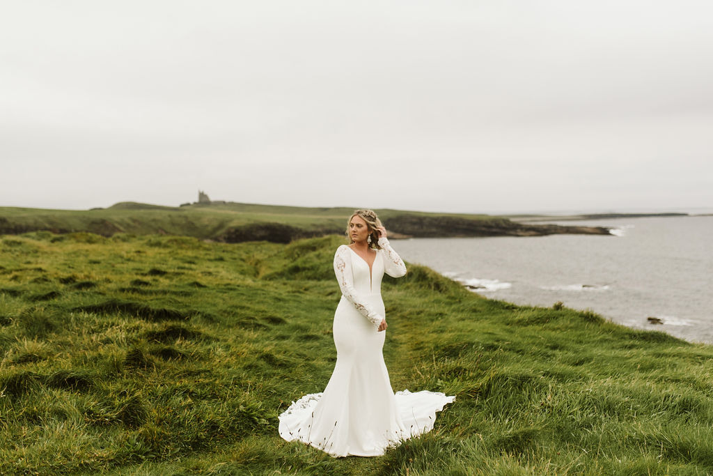 Bride wearing a fitted long sleeve wedding dress with lace at Mullaghmore Head in Ireland
