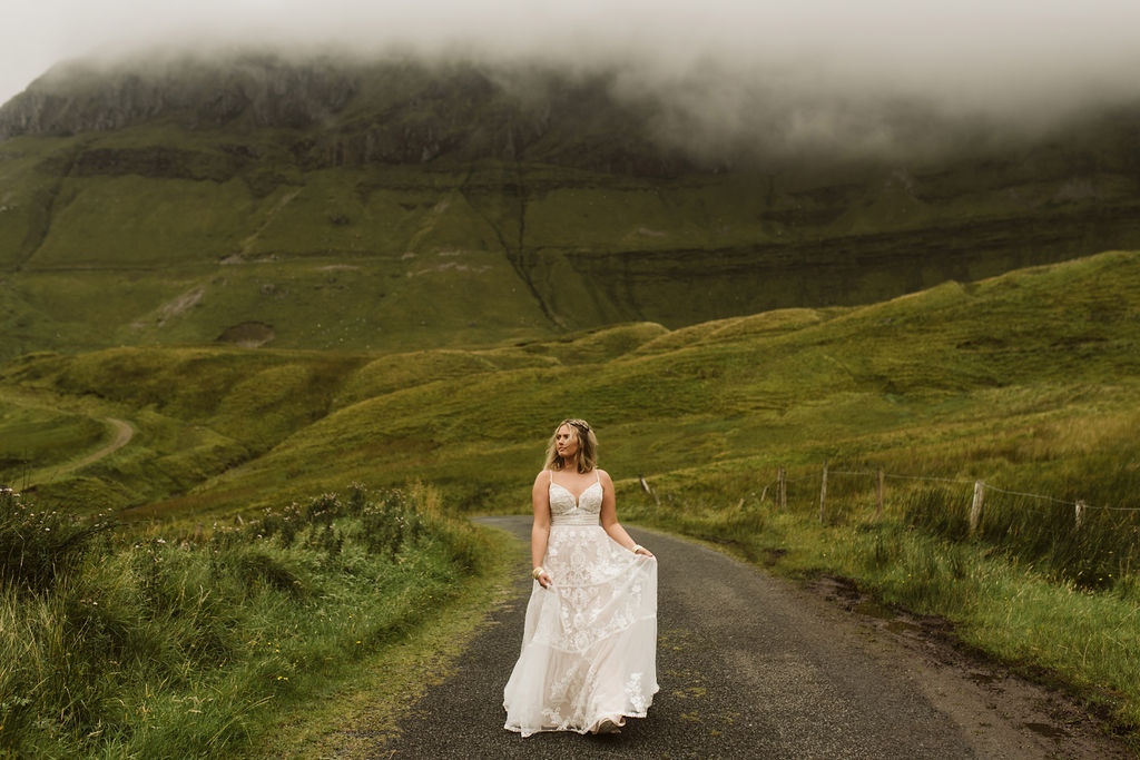 Bride in middle of road at Gleniff Horseshoe Drive in Ireland wearing a lace boho wedding dress