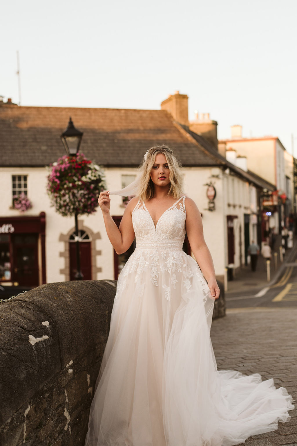 Bride walks along bride in Westport Ireland wearing a lace and tulle wedding dress with lace straps