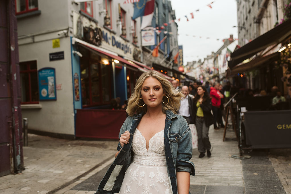 Bride wears a jean jacket and a lace boho wedding dress in the streets of Galway Ireland