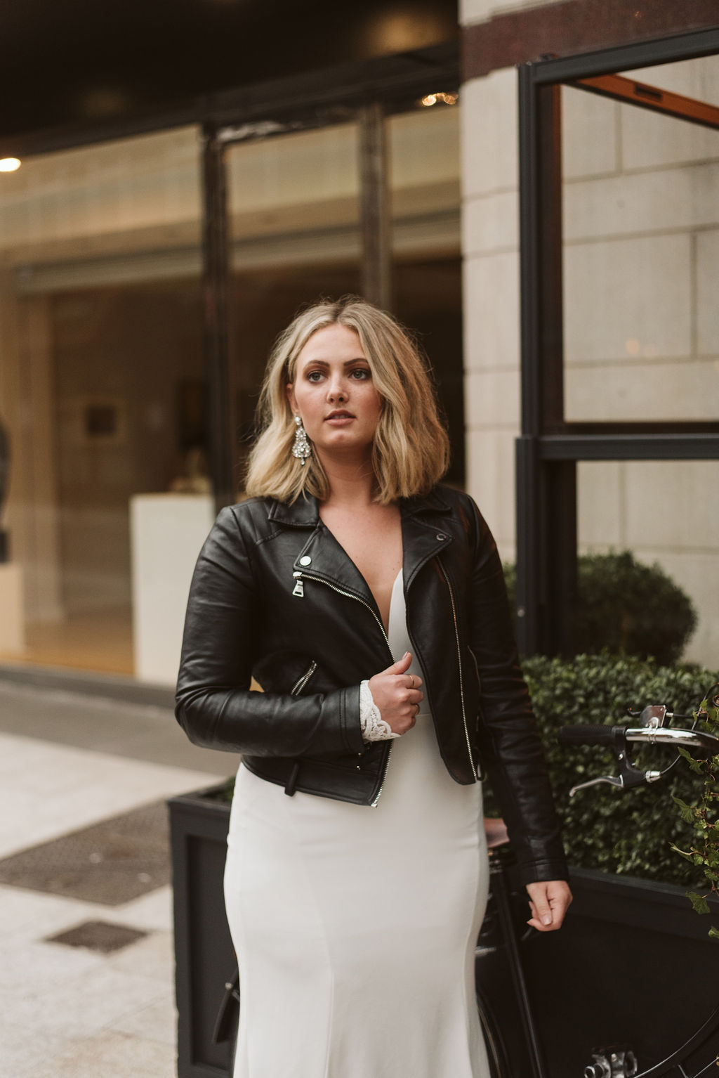 Bride wearing a simple wedding dress and leather moto jacket in Dublin Ireland