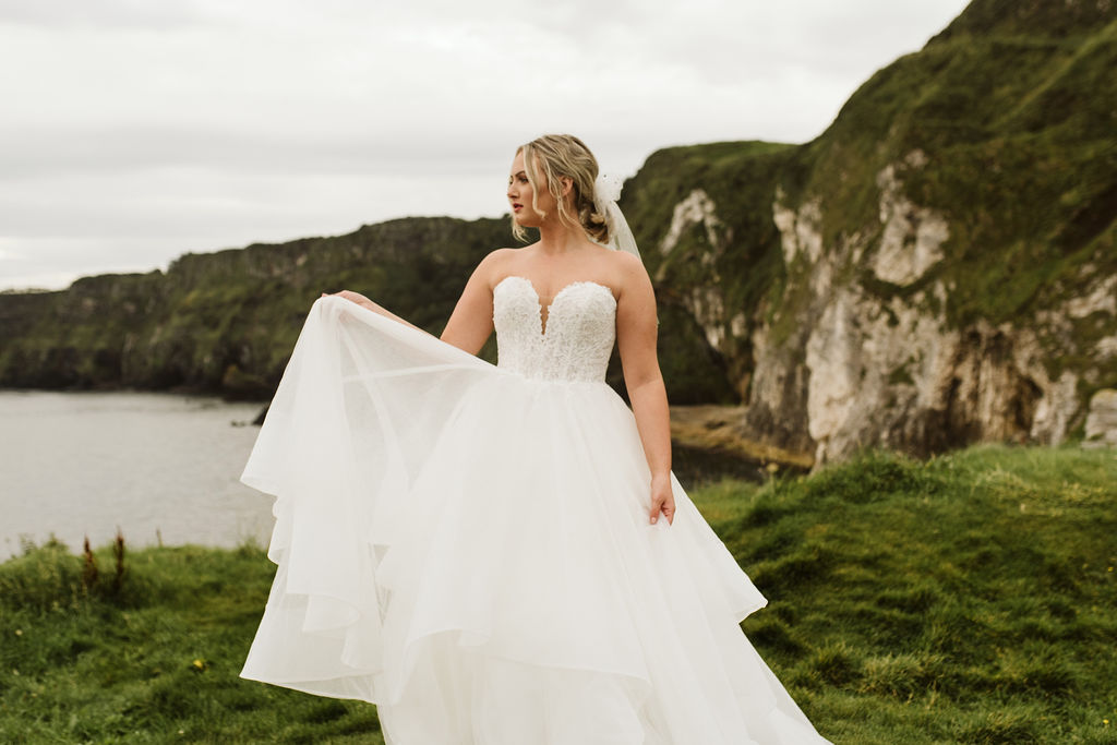 Bride wearing a ballgown wedding dress and tulle bow at Kinbane Castle ruins in Ireland 