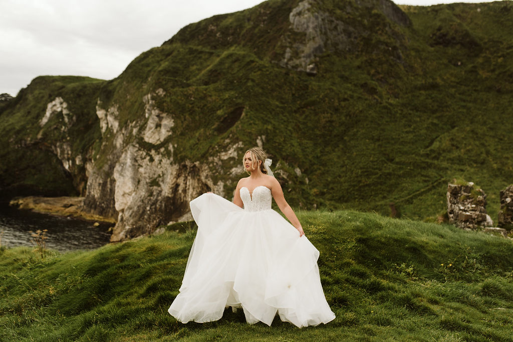 Bride wearing a ballgown wedding dress and tulle bow at Kinbane Castle ruins in Ireland