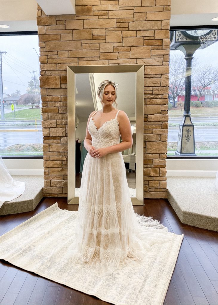 Bride stands in lace and fringe ballgown at One Fine Day Bridal and Gown Boutique in Fort Wayne, Indiana