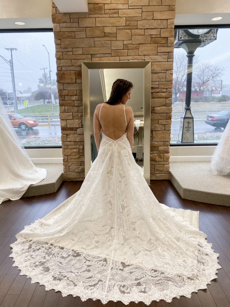 Bride stands in a high neck lace aline boho wedding dress at One Fine Day Bridal and Gown Boutique in Fort Wayne, Indiana