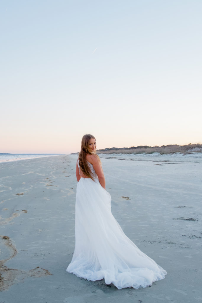 open back wedding dress on beach at sunrise